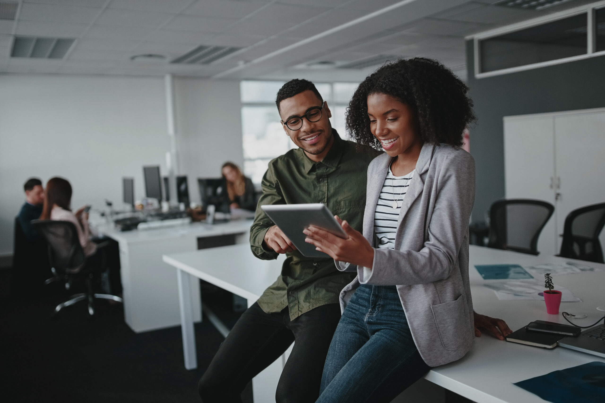 Successful african american business couple talking and using digital tablet