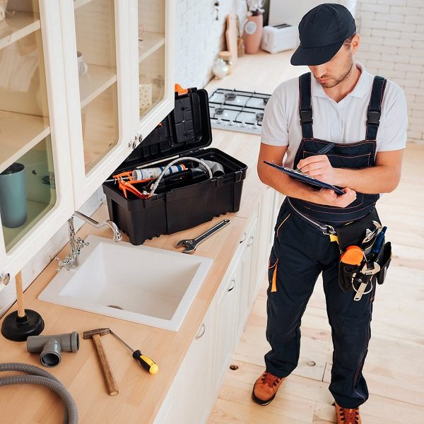 Handyman making notes about potential repairs at a jobsite.