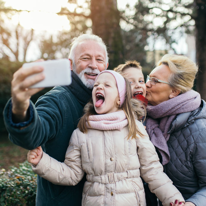 Grandparents taking cell phone pic with grandchildren