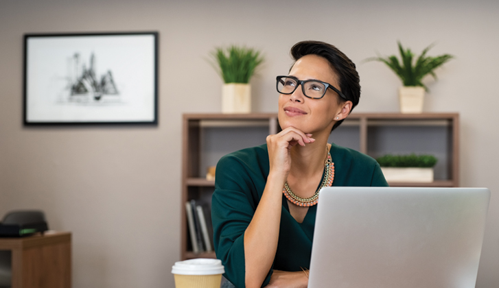 Young businesswoman with glasses and light smile ponders decisions.