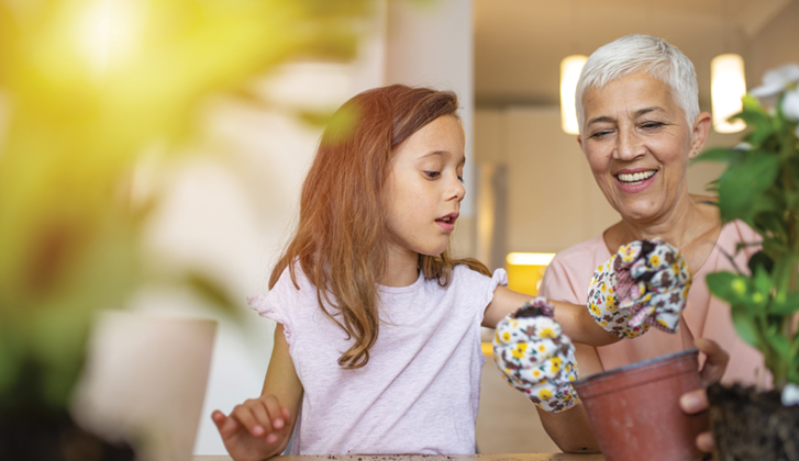 Grandmother and child potting flowers