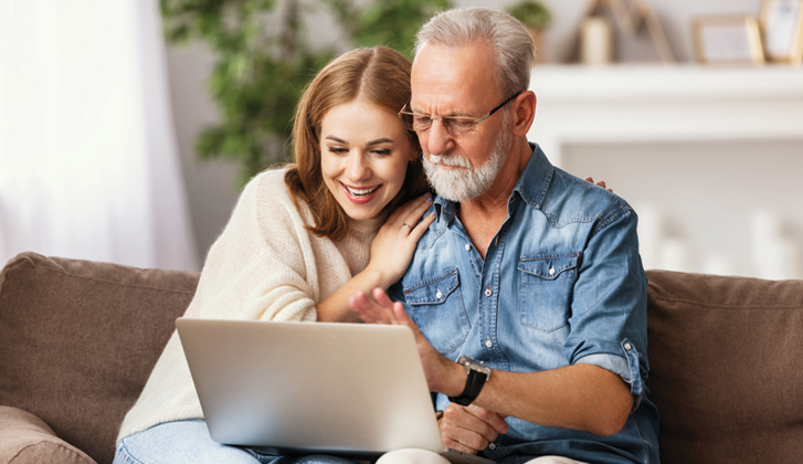 Father and daughter looking at a laptop