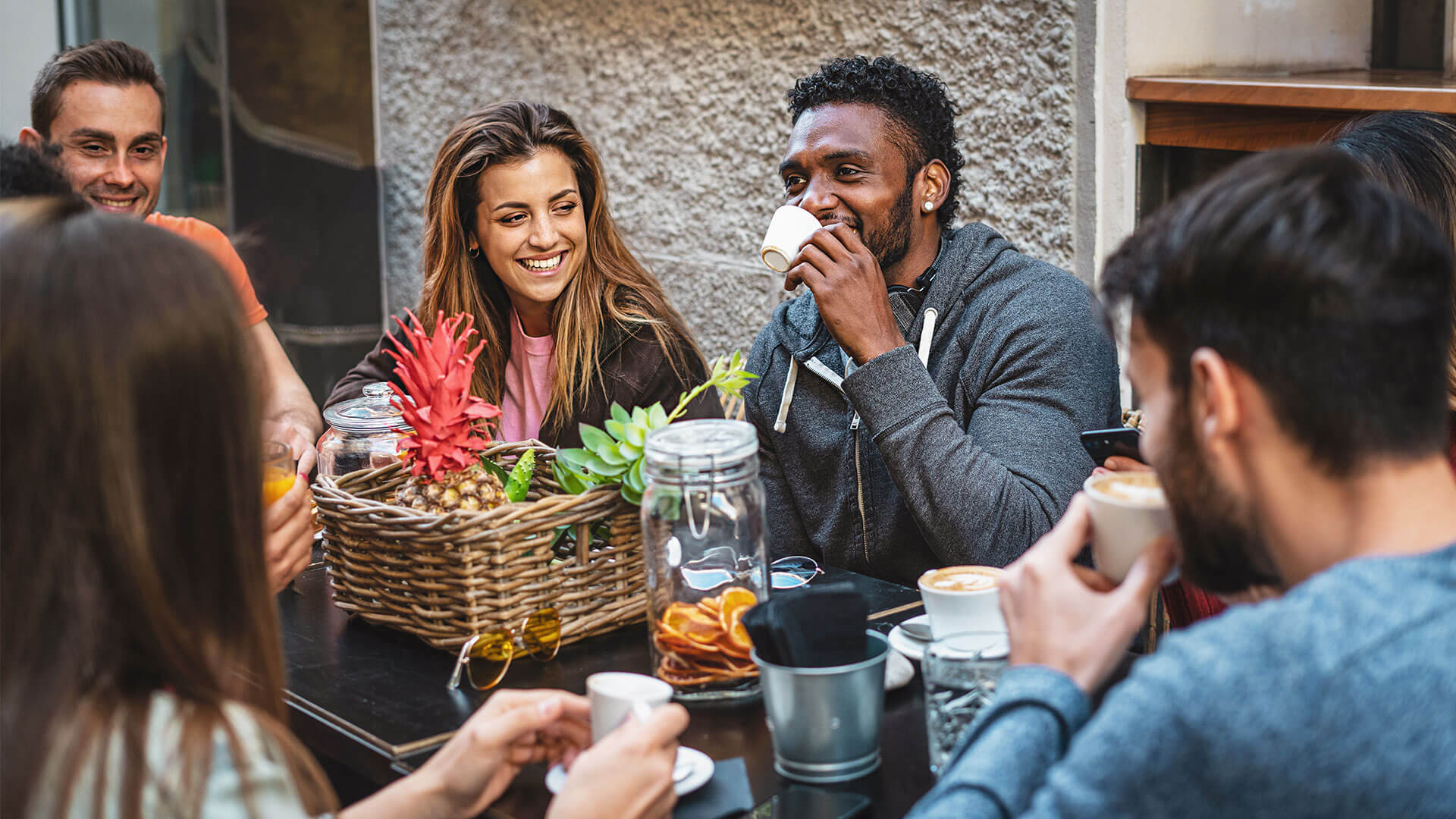 Group of people sitting outside drinking coffee