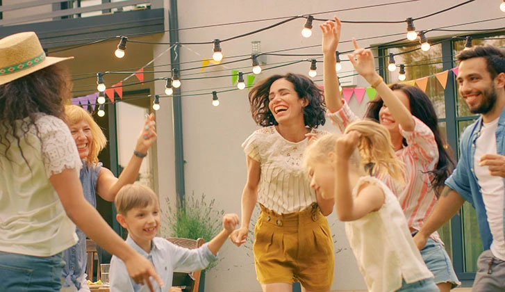 Family and Friends Dancing together at the Garden Party Celebration. Young and Elderly People Having Fun on a Sunny Summer Day Disco.